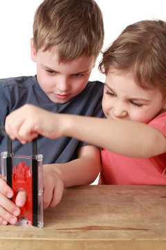 Brother and sister play with  little guillotine