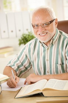 Portrait of elderly man working at desk