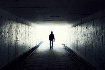 Fototapete Tunnel Schattenbild des Mannes, der im Tunnel geht. Licht am Ende des Tunnels