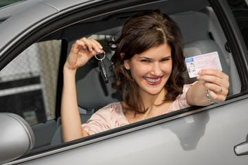 Frau mit Autoschlüssel und Führerschein