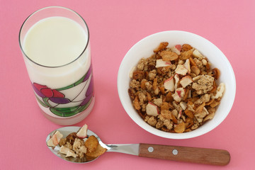 cereals in a bowl with glass of milk