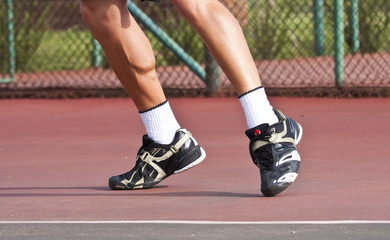 Fototapeta na wymiar Tennis player legs and feet on court playing