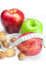 apple, nuts and measure  tape isolated on white