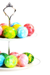 Colorful Easter eggs in a vase on a white background.
