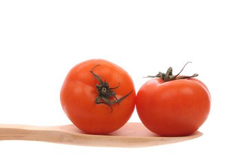 tomatoes on a wooden spoon isolated on a white background
