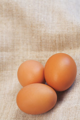 Fresh brown eggs on a beige fabric background