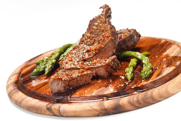 Grilled steak with Green asparagus on wooden background