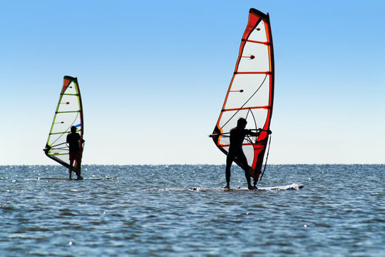 Silhouette of a two windsurfers