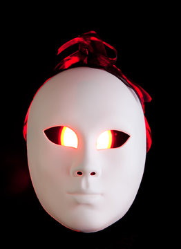 Scary white mask with red eyes