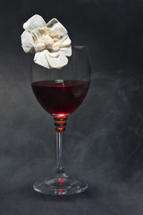 Glass of red wine and a flower isolated on black background