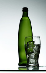 Purified mineral water on the wet glass desk with reflection