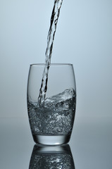 Stream of water falling in glass