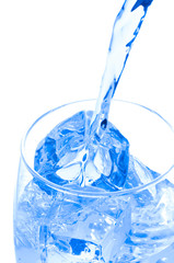 Stream of water falling in glass with ice
