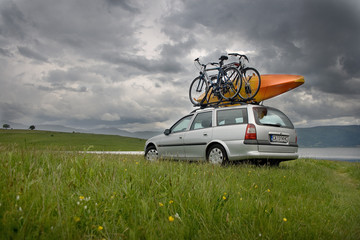 Kayak and bicycles on a car at a lake