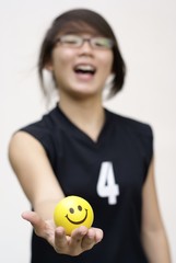 Asian lady holding yellow happy ball in hand