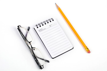 Glasses and pencil with notepad