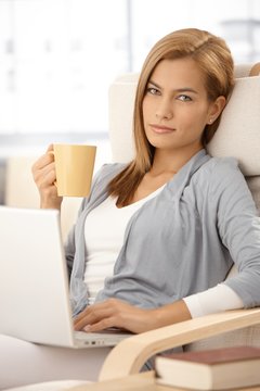Attractive woman with coffee and laptop