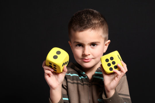 bambino mostra dadi gialli