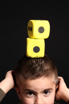 bambino con dadi gialli sulla testa