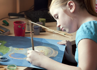 Девочка левша рисует картину красками