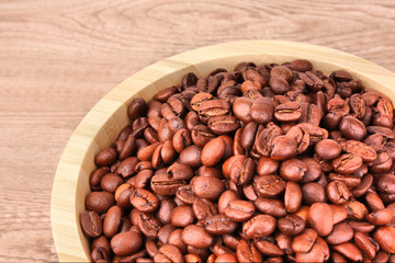 Plate with coffee beans on wooden table