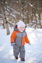 Fototapeta na wymiar Adorable baby walking in winter sunny park