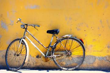 Old bike against the wall at home - obrazy, fototapety, plakaty