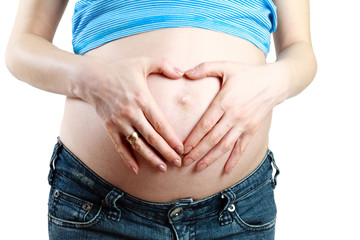 Hands of a pregnant woman making a heart with hands on her belly