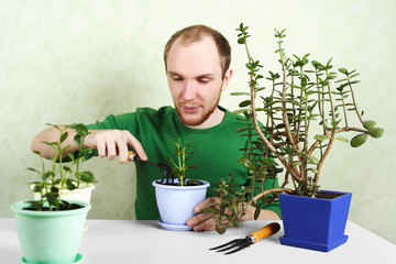 man sitting near table with gardening equipment and pronging gro