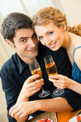 Young couple celebrating with champagne at home