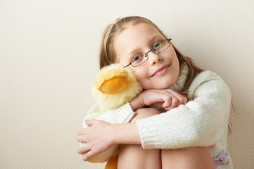 Portrait of a  little girl in eyeglasses with a toy