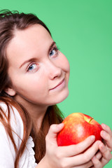 portrait of the beauty girl with red color apple in park