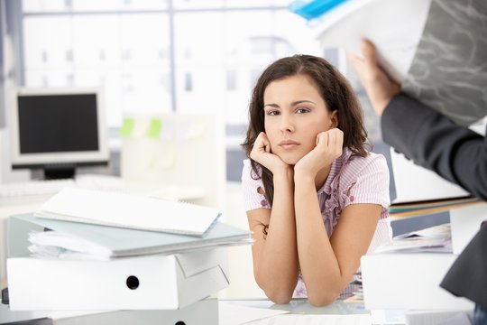 Attractive girl sitting among folders in office