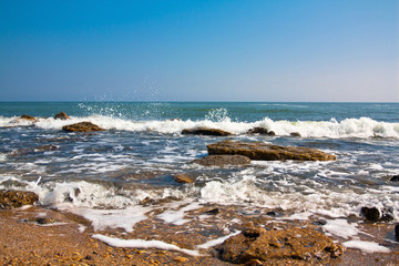 Fototapeta na wymiar Sea landscape of a wave breaking about stones