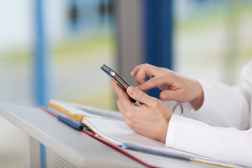frau am stehpult tippt auf handy
