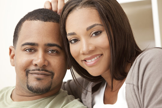 Happy African American Couple Sitting At Home