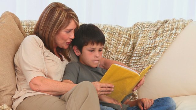 A grandmother reading a book to her grandson