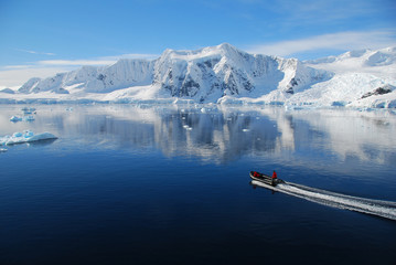Naklejka premium boat cruises through antarctic landscape