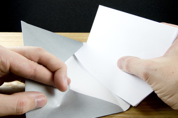 opening envelope with fingers crossed