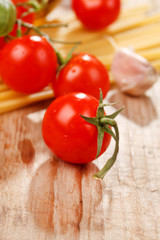 pasta, olive oil and tomatoes on the wood background
