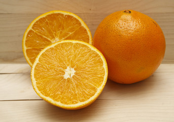 Cut and Whole Orange on Wood Board