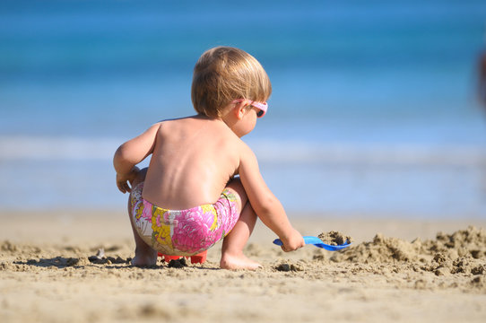 Ni&ntilde;o jugando en la playa con la arena