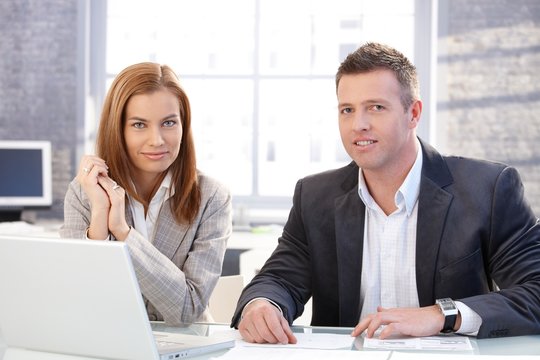 Attractive businesspeople working on laptop