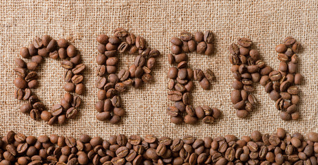 The word Open from coffee beans on linea material