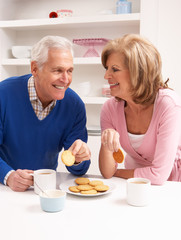 Senior Couple Enjoying Hot Drink In Kitchen