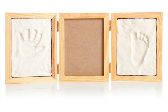 Blank photo frame with hand and foot prints of a child| Isolated