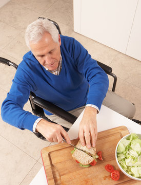 Disabled Senior Man Making Sandwich In Kitchen