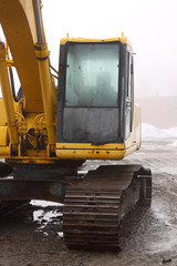 Backhoe cabin on wet and foggy day