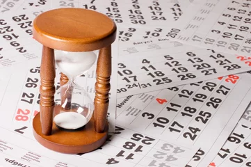 Fotobehang hourglass on calendar sheets © Vladimir Voronin
