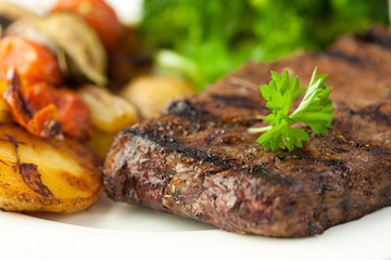 Closeup of grilled steak with baked vegetables